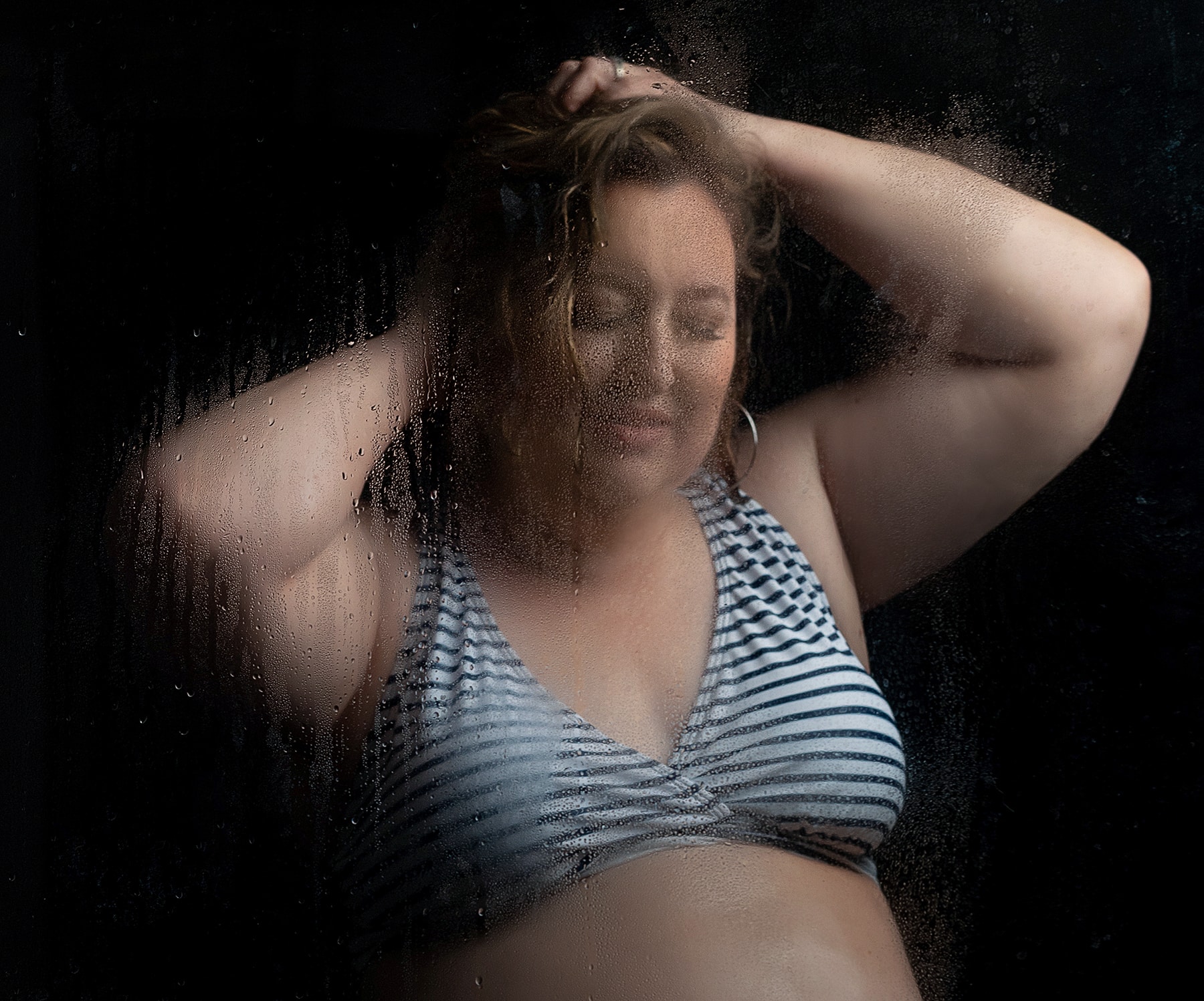 Plus size woman wears striped bikini top for a boudoir session with Shannon Hemauer Photography located near Harrisburg, PA.