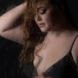 Woman wearing a black bathing suit for a boudoir shower session with Shannon Hemauer Photography.